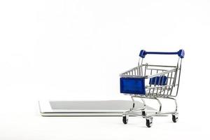 shopping cart with tablet on white backgrond , Means shopping online photo