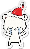 crying distressed sticker cartoon of a polarbear wearing santa hat vector