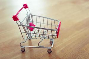 carrito de compras en la mesa y la luz del sol concepto de compras en línea de fondo del mercado moderno foto