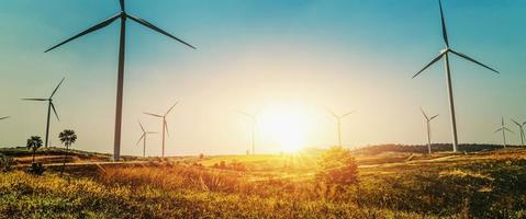 concepto idea energía ecológica en la naturaleza. turbina de viento en la colina y puesta de sol foto