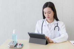 Asian female doctors use tablets to consult information. photo