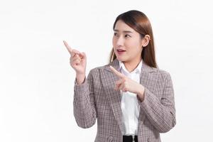 An Asian working woman in a formal suit in a white shirt and shows point up to present something on white background. photo