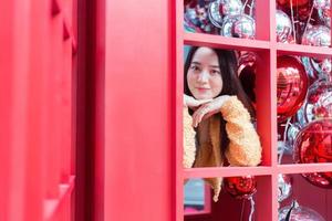 Asian beautiful woman long haired  wearing a yellow robe  and smile happy standing in red telephone booth In the theme of celebrating Christmas and Happy New Year photo