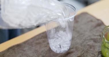 ijsblokje in een plastic glas gieten. video