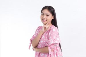 Portrait Asian beautiful woman in pink dress and black long hair. Her hands touch cheek, smile, show beautiful skin on white background. photo