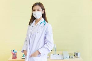Professional Asian woman doctor wears medical coat and face mask  in health care,pollution PM2.5 and coronavirus protection concept photo