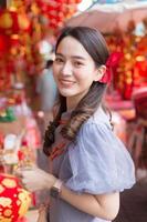 Asian beautiful woman in long hair wears a grey Chinese dress or qipao with Chinese new year theme. photo