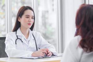 Asian professional  female doctor suggests healthcare solution to her patient elderly in examination room at hospital. photo