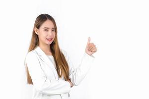 Young Asian professional woman with bronze long hair wearing a white suit pretty smiling and thumbs up is present product on white background.
