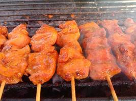 Skewer chicken pieces roasting on the grill and smoke. Grilled chicken photo