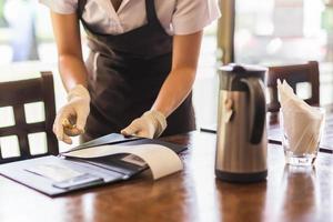 Waiter is giving a bill to customer in restaurant. photo