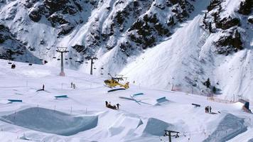 reddingshelikopter die op de hellingen landt en skiër helpt in een skipark. luchtambulance in alpen. redding vervoer. video