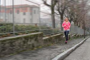 Girl runs on the sidewalk in the city photo