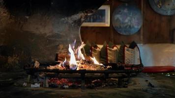 Kamin in einer gemütlichen Kabine. gemütliches Waldhaus mit brennendem Kamin. entspannende Umgebung. Innenraum eines Holzhauses mit Fenster. 4k-Video. video