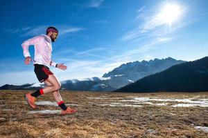 Mountain runner in downhill action on slippery ground photo