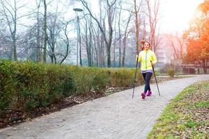 Girl make Nordic walking in the park in the city photo