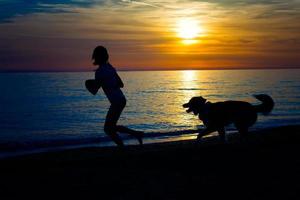 chica con perro en la playa foto