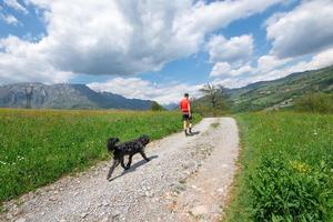 hombre durante el paseo por las montañas con su perro que lo sigue