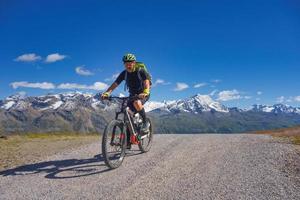 Mountain biking in the high mountains on a dirt road photo