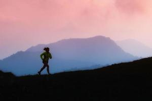 Sports girl runs in the mountains alone photo