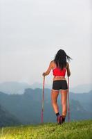 Sporty woman with nice body looks at the panorama in the mountains during on trekking photo