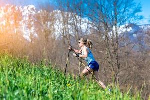 Girl runs with sticks in the mountains photo