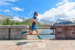 Mountain runner passes over an alpine dam photo