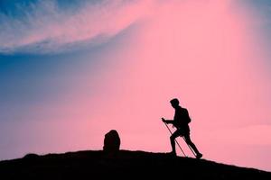 silueta de chica que hace trekking en un atardecer rosa foto