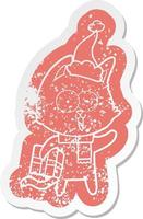 funny cartoon distressed sticker of a cat wearing santa hat vector