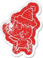 laughing bear cartoon distressed sticker of a wearing santa hat vector