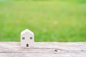 Wooden house model on wooden textured with green natural and sunlight background, Green Ecology Concept and copy space photo