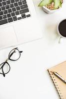 Laptop with cup of coffee on business desk office with copy space, Top view photo