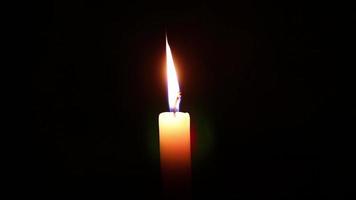 Candle flame against isolated black background video
