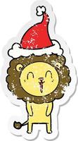 laughing lion distressed sticker cartoon of a wearing santa hat vector