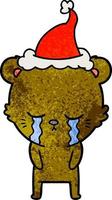 crying textured cartoon of a bear wearing santa hat vector