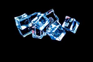 Ice cubes on a black background. ice falling on a black background for use as an illustration in a project photo