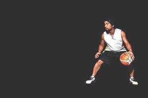 Gesture of Asian basketball player dribbling on black background. Basketball concept in Asia photo