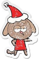 distressed sticker cartoon of a bored dog wearing santa hat vector