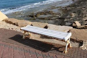 Bench for rest in a city park on the shores of the Mediterranean Sea. photo