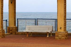 Bench for rest in a city park on the Mediterranean coast in northern Israel photo