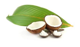 Fresh break coconut - tropical fruit and leaves on white background photo