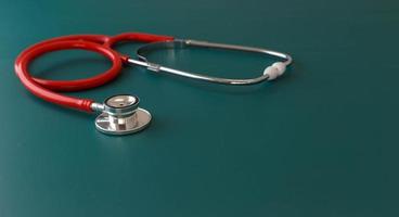 Red stethoscope on green background photo