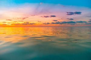 Sunset sea seascape. Colorful ocean beach sunrise. Beautiful beach scenery with calm waves and soft sandy beach. Empty tropical landscape, horizon with scenic coast view. Colorful nature sea sky photo