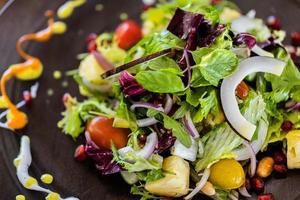 Green salad with sliced avocado, cherry tomatoes, black olives and cheese. Healthy diet vegetarian summer vegetable salad. Table setting. Food concept. Top view. photo