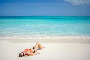 Woman relaxing on the beach. Young slim beautiful woman on tropical seaside beach. Summer vacation, sunny photo