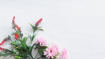 Flat lay flowers on white wood background photo