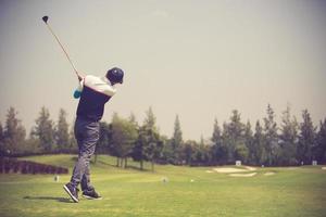 Golfers hit sweeping golf course in the summer.Vintage color photo