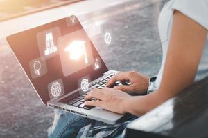 capacitación en educación en línea, mano de una persona usando una computadora portátil con fondo de icono de educación en pantalla vr, seminario web en línea. foto