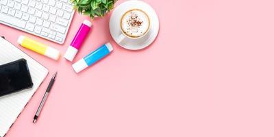 Office desk with keyboard computer, Blank screen smart phone, cup of coffee, pen, notebook on pink background, Top view with copy space, Mock up. photo