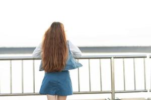 Hipster young girl enjoying sunset on bridge. Tourist traveler on background view mockup. photo